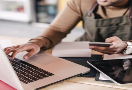 person with phone and laptop